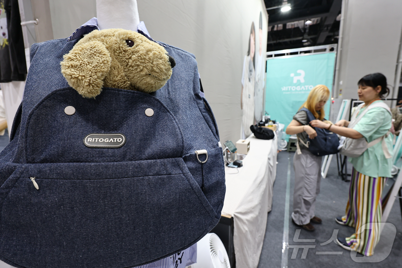 (서울=뉴스1) 김도우 기자 = 13일 서울 강서구 코엑스 마곡에서 열린 '2025 케이펫페어'에서 관람객들이 반려동물 포대기를 살펴보고 있다.이번 전시회에는 반려동물 사료, 용품 …