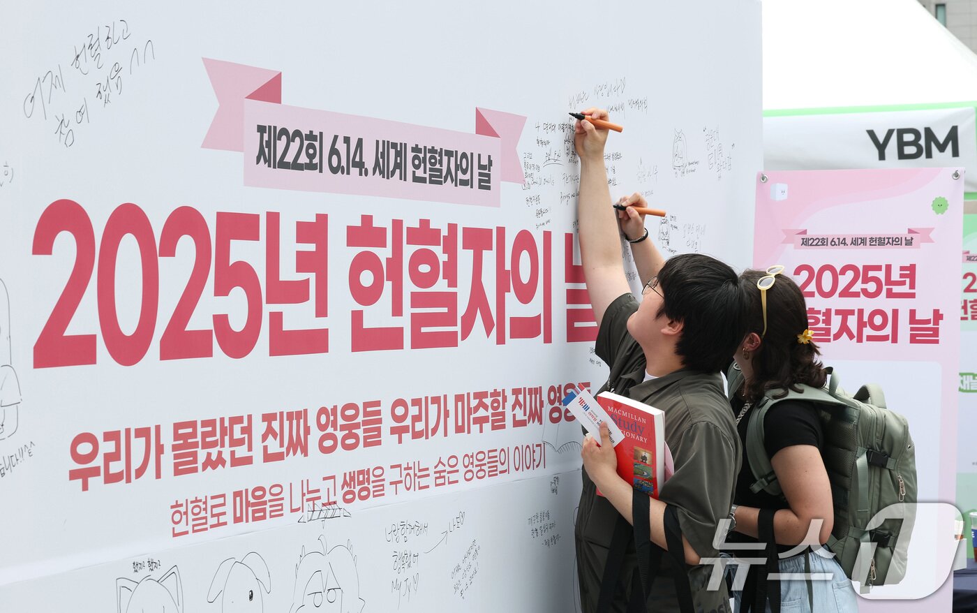 본문 이미지 - 13일 서울 종로구 광화문광장에서 열린 2025년 헌혈자의 날 행사에서 시민들이 게시판에 글을 남기고 있다. 2025.6.13/뉴스1 ⓒ News1 임세영 기자