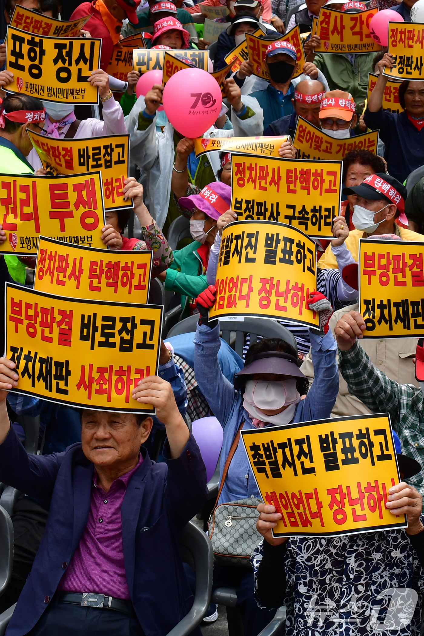 (포항=뉴스1) 최창호 기자 = 13일 오후 경북 포항시 북구 육거리 실개천에서 열린 포항지진 정신적피해보상 항소심 기각 판결에 항의하는 대시민 궐기대회에서 시민들이 구호를 외치고 …