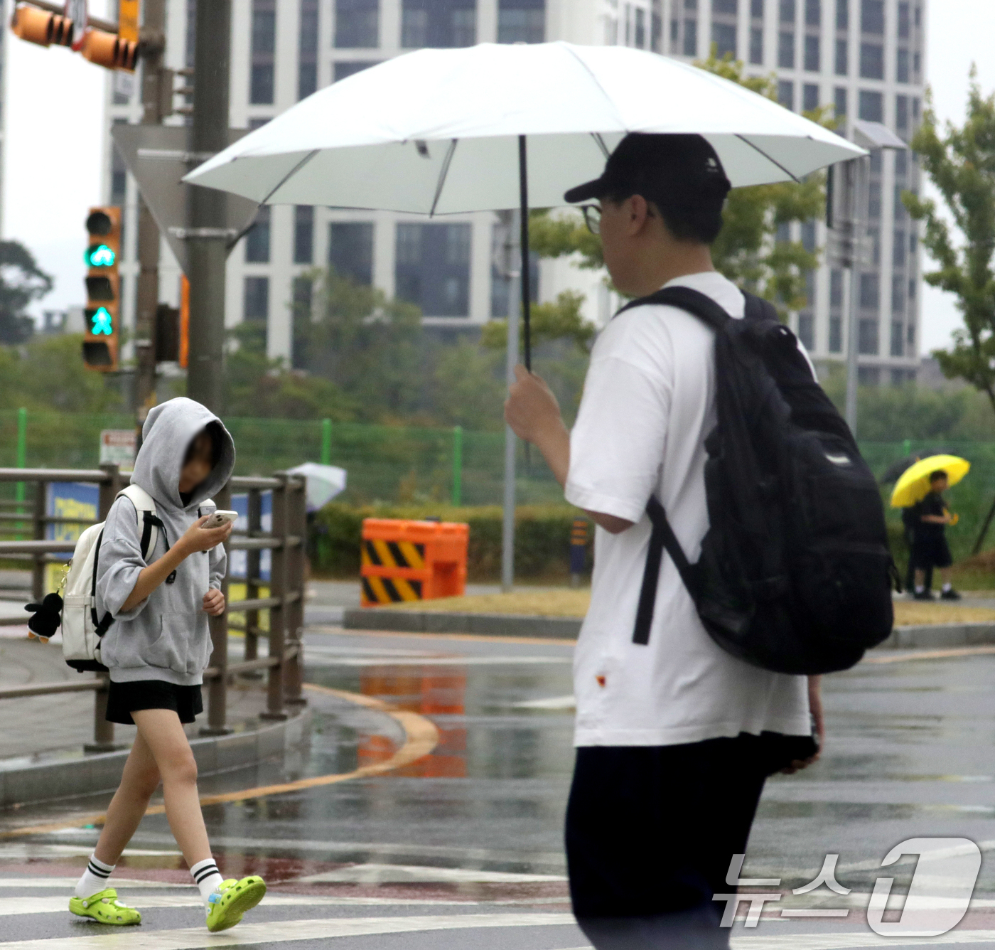 (전주=뉴스1) 유경석 기자 = 장맛비가 내리는 13일 전북 완주군 한 초등학교 앞 횡단보도에서 우산을 쓴 시민들이 발걸음을 재촉하고 있다. 2025.6.13/뉴스1