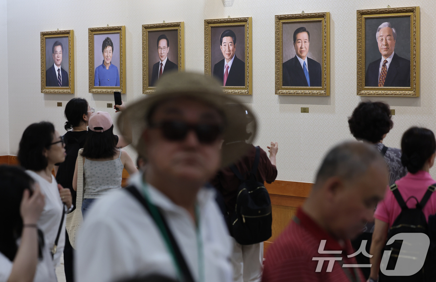 (서울=뉴스1) 이동해 기자 = 15일 서울 종로구 청와대 본관 내부 세종실 앞 공간에 걸린 역대 대통령의 초상화를 관람객들이 살펴보고 있다. 2025.6.15/뉴스1