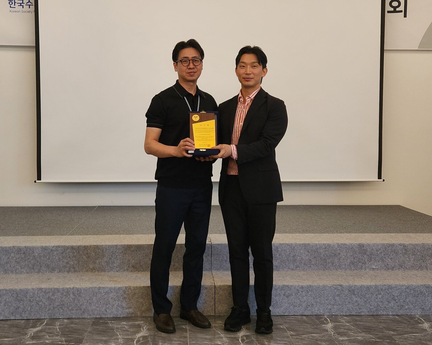 본문 이미지 - 최춘기 한국수의재활학회 회장&#40;왼쪽&#41;이 김일천 마디마디 신경외과병원 원장 강의 후 감사패를 증정하고 기념 사진을 찍고 있다. ⓒ 뉴스1 한송아 기자