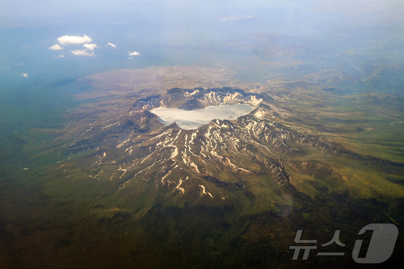 (지린성(중국)=뉴스1) 황기선 기자 = 지난 13일(현지시간) 오전 연길공항에서 인천공항으로 가는 비행기 탑승 중 창가에서 바라본 백두산 천지의 모습. (공동취재) 2025.6. …