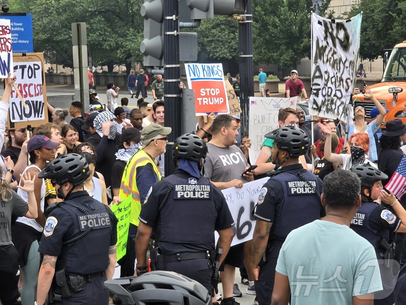 (워싱턴=뉴스1) 류정민 특파원 = 14일(현지시간) 미국 수도 워싱턴DC에서 미 육군 창설 250주년 열병식이 열린 가운데, 도널드 트럼프 행정부 정책에 반대하는 참가자들이 경찰 …