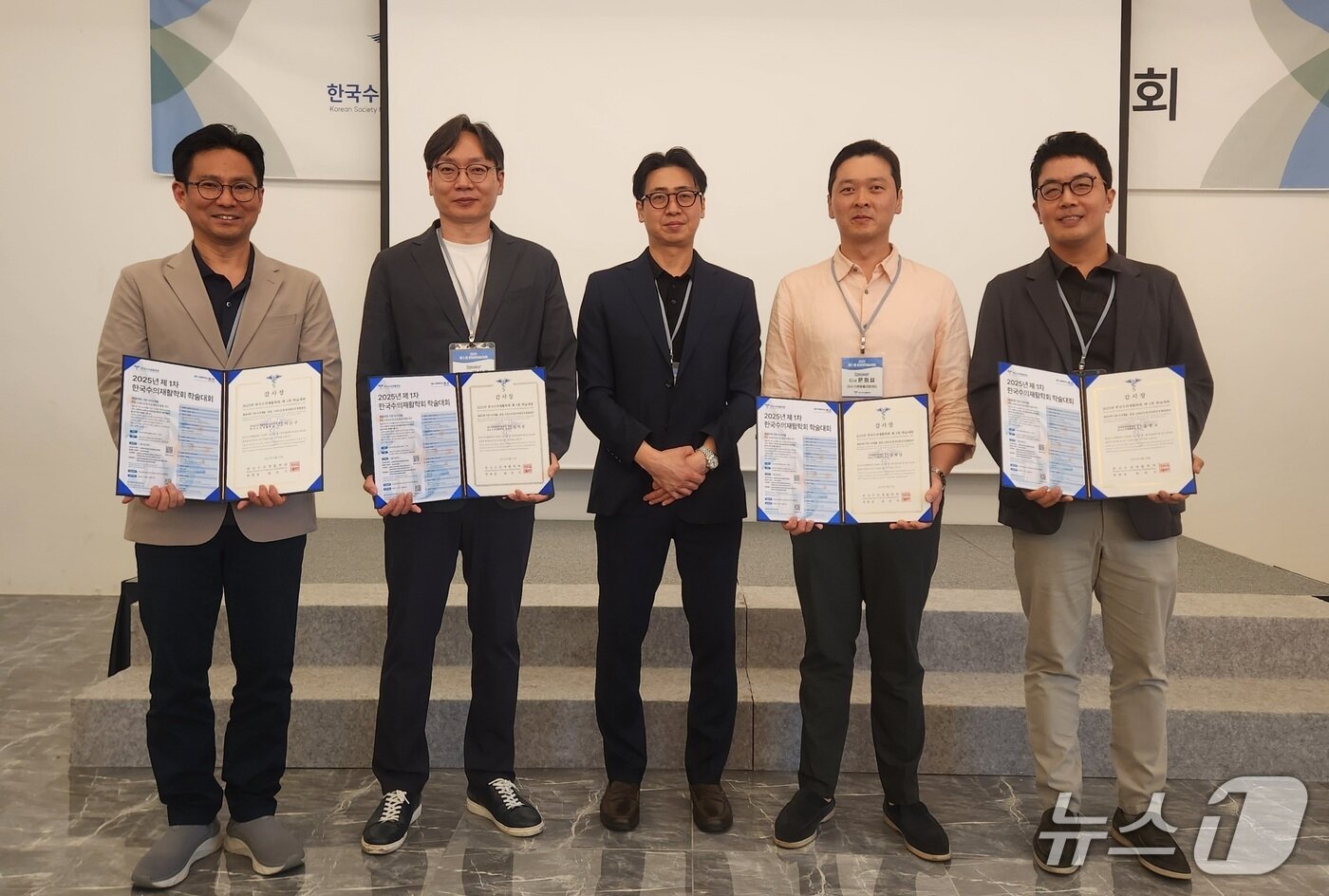 본문 이미지 - 2025 제1차 한국수의재활학회 학술대회에서 치료 사례를 발표한 강사들이 최춘기 회장&#40;가운데&#41;으로부터 감사패를 받고 기념 사진을 찍고 있다. ⓒ 뉴스1 한송아 기자