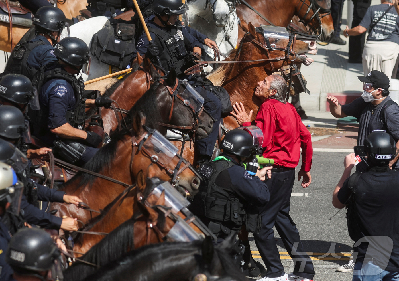 (로스앤젤레스 로이터=뉴스1) 류정민 특파원 = 14일(현지시간) 미국 캘리포니아주 로스앤젤레스(LA)에서 도널드 트럼프 미국 대통령의 정책과 연방 이민 단속에 반대하는 '노 킹스 …