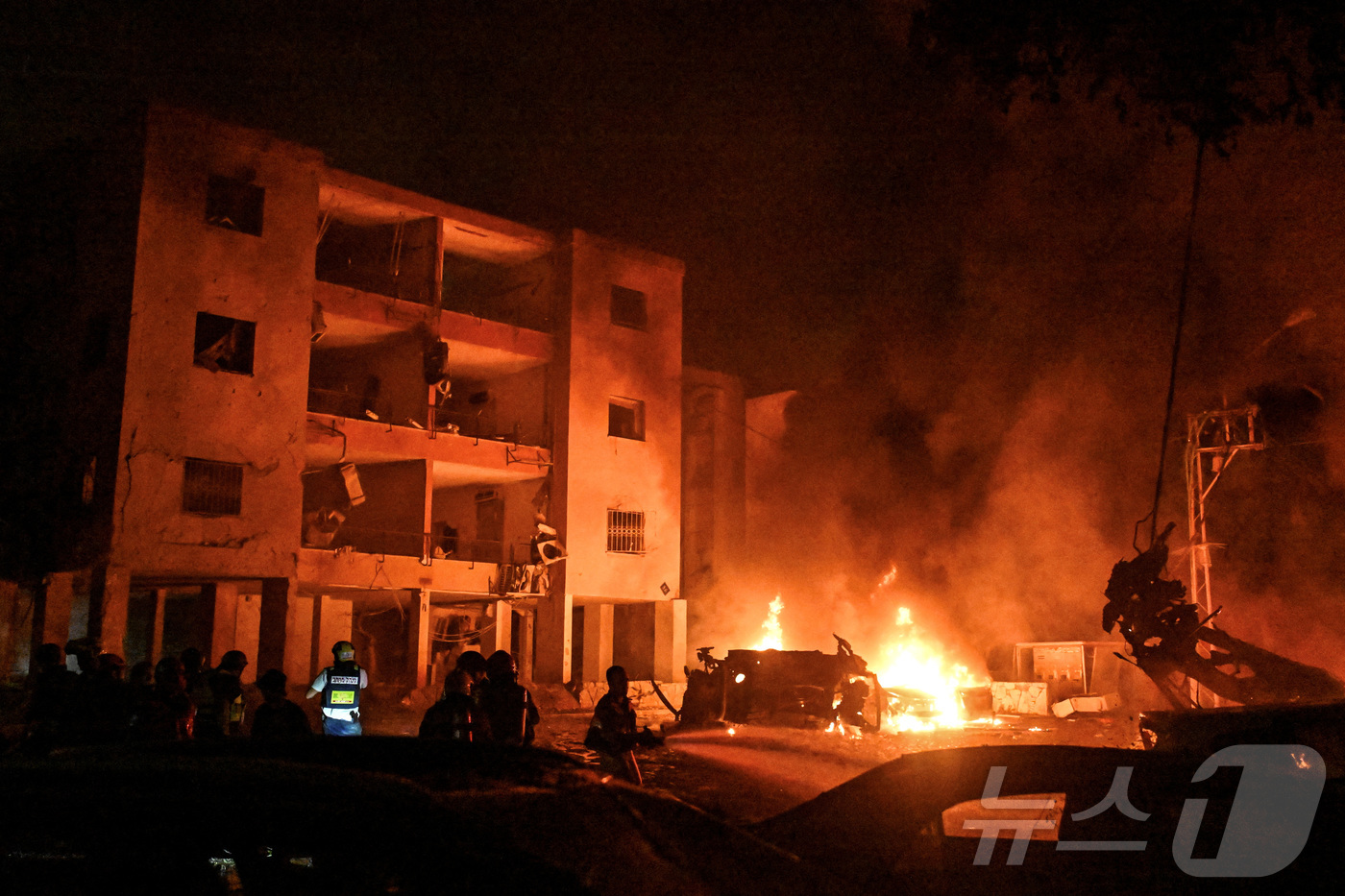 (이스라엘 하이파 로이터=뉴스1) 신기림 기자 = 2025년 6월 15일 이스라엘 북부 하이파에서 이란 미사일 공격으로  건물에 발생한 화재로 소방관과 구조 요원들이 작업하고 있다 …