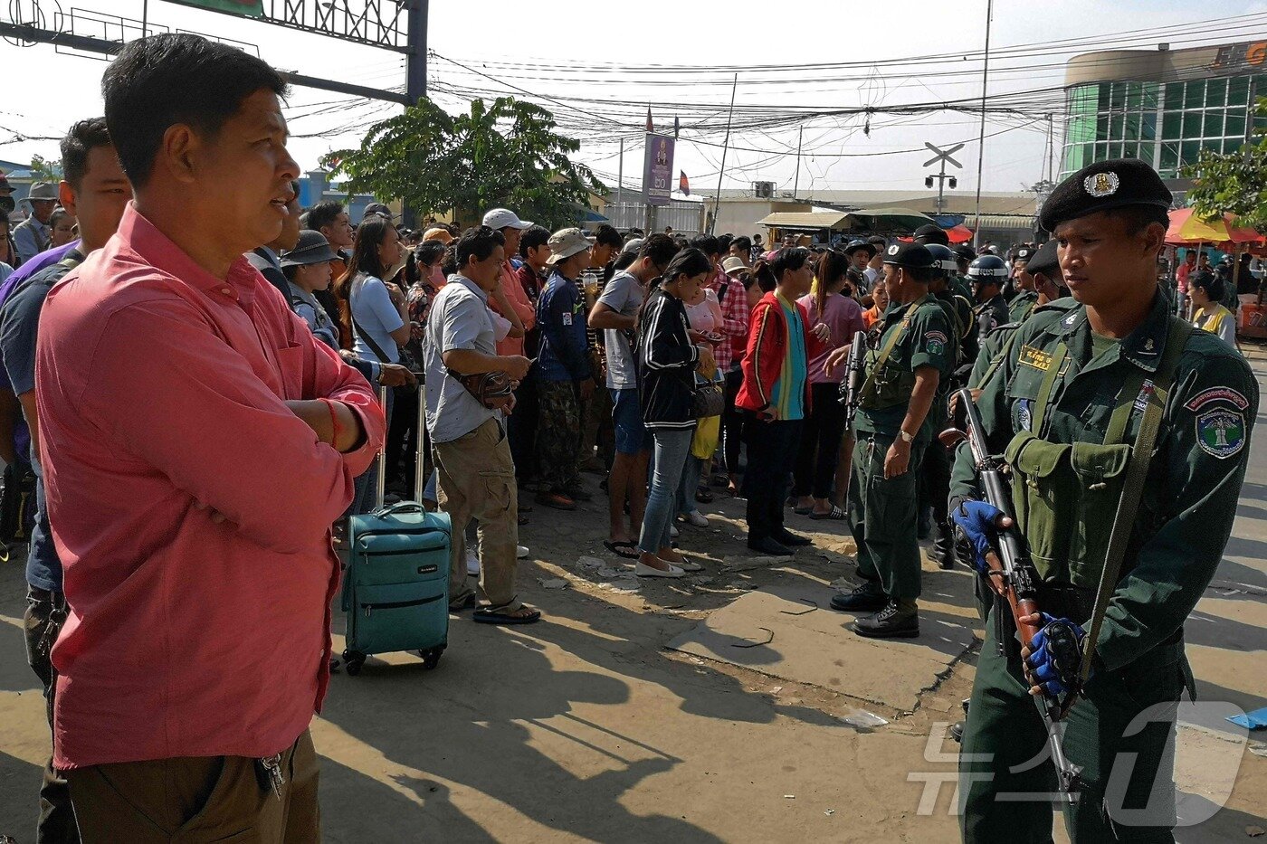 본문 이미지 - 캄보디아 경찰이 태국으로 국경을 넘으려는 사람들을 검문하고 있다. 2019.11.09. ⓒ AFP=뉴스1 ⓒ News1 이창규 기자
