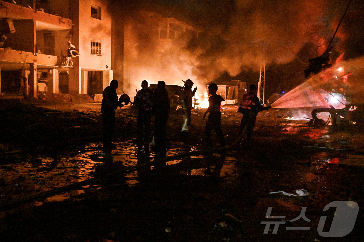 (하이파 로이터=뉴스1) 강민경 기자 = 15일 이란의 보복성 미사일 공격을 받은 이스라엘 북부 항구도시 하이파에서 소방관과 구조대원들이 화재 현장에 출동해 있다. 2025.6.1 …