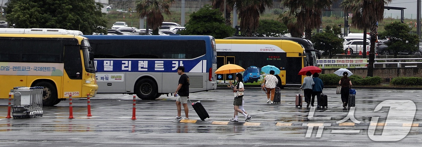 (제주=뉴스1) 고동명 기자 = 장맛비가 내린 16일 오전 제주시 제주국제공항에서 관광객들이 비를 피하고 있다.2025.6.16/뉴스1