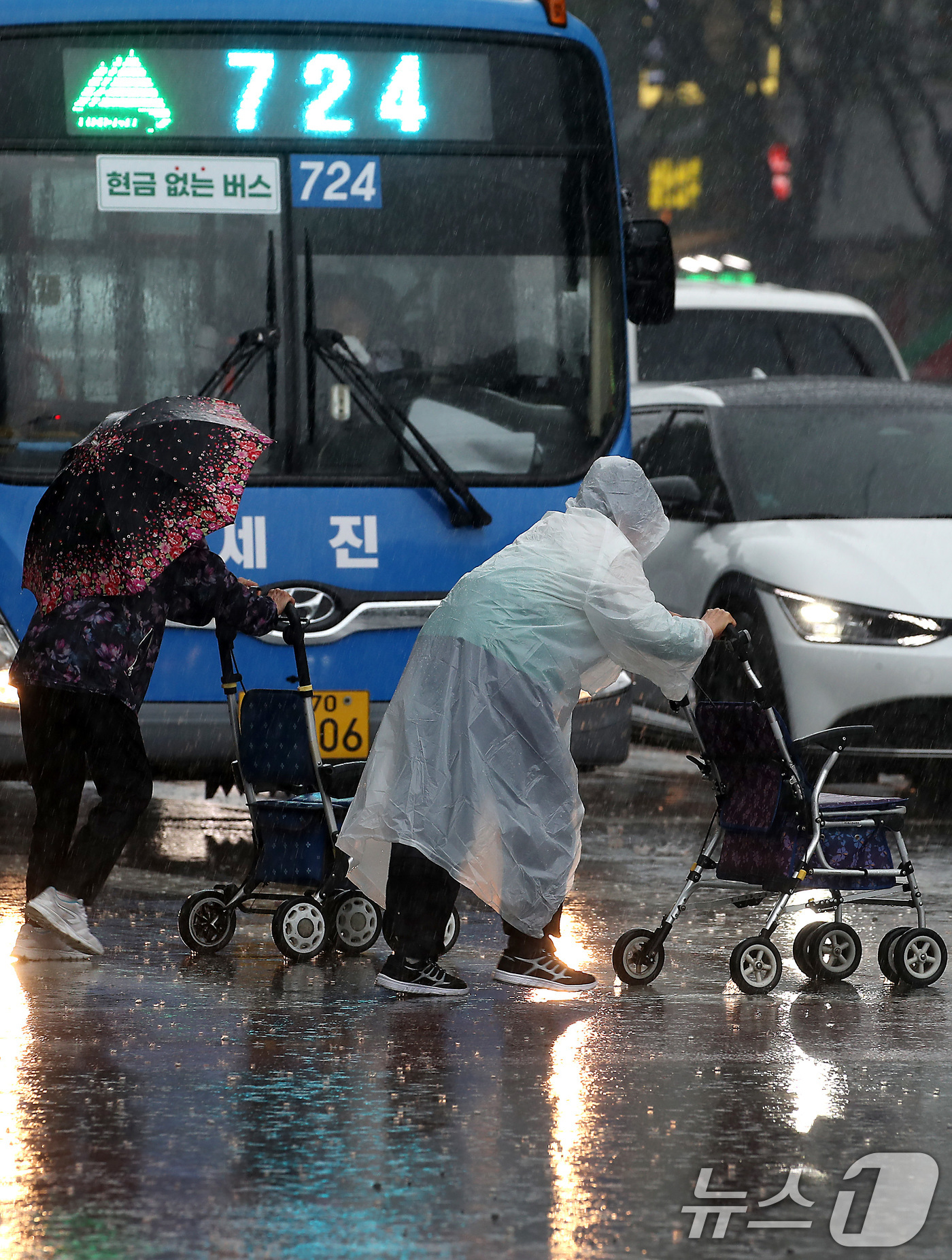 (대구=뉴스1) 공정식 기자 = 16일 오전 비가 요란하게 내리는 대구 수성구 달구벌대로 한 횡단보도에서 어르신이 보행보조기(어르신 유모차)에 의지한 채 길을 건너고 있다. 202 …