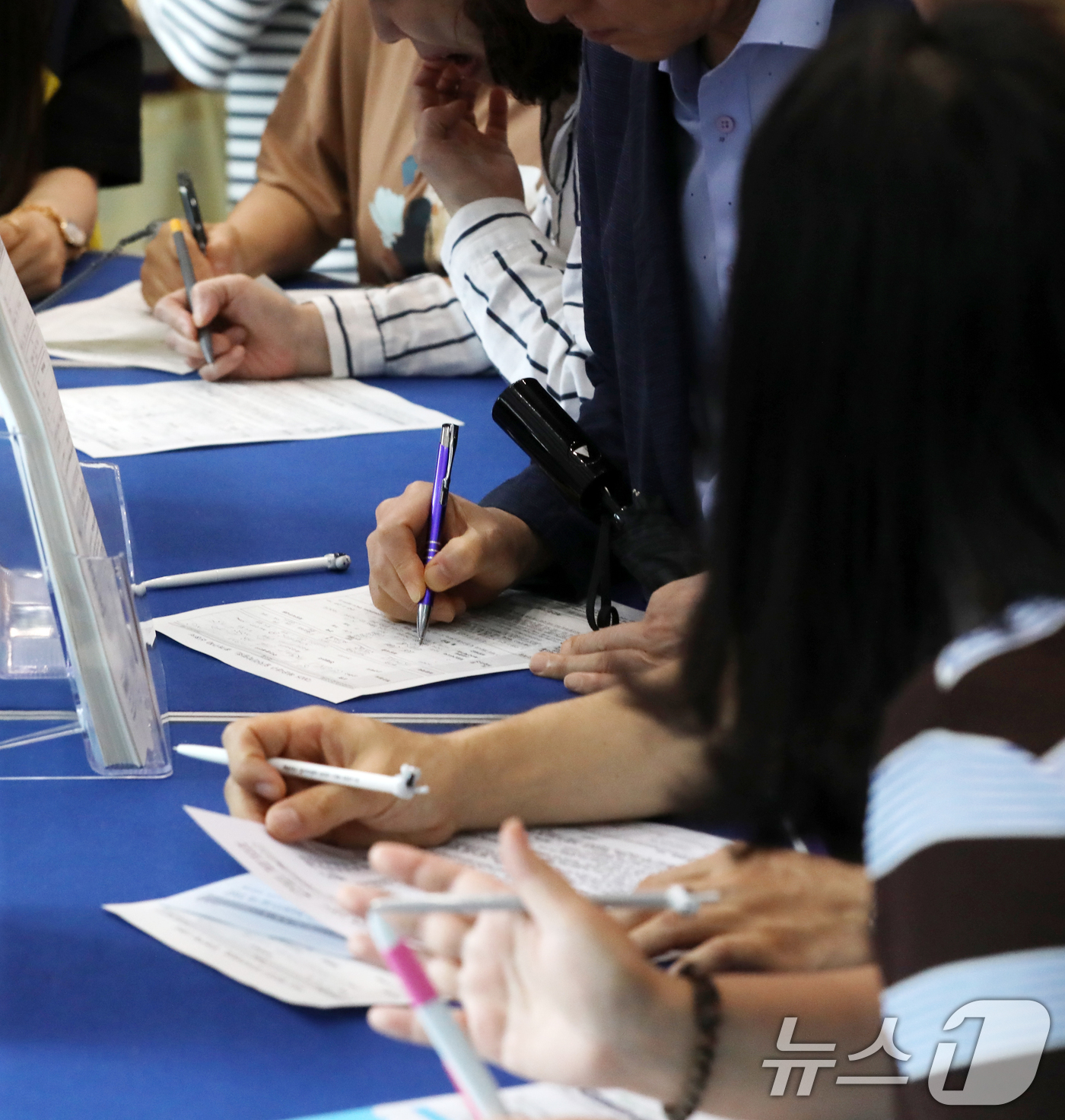(부산=뉴스1) 윤일지 기자 = 16일 오후 부산 해운대구 벡스코 제1전시장 컨벤션홀에서 열린 '2025 해운대구 일자리박람회'에서 구직자들이 참가 신청서를 작성하고 있다.구직자와 …