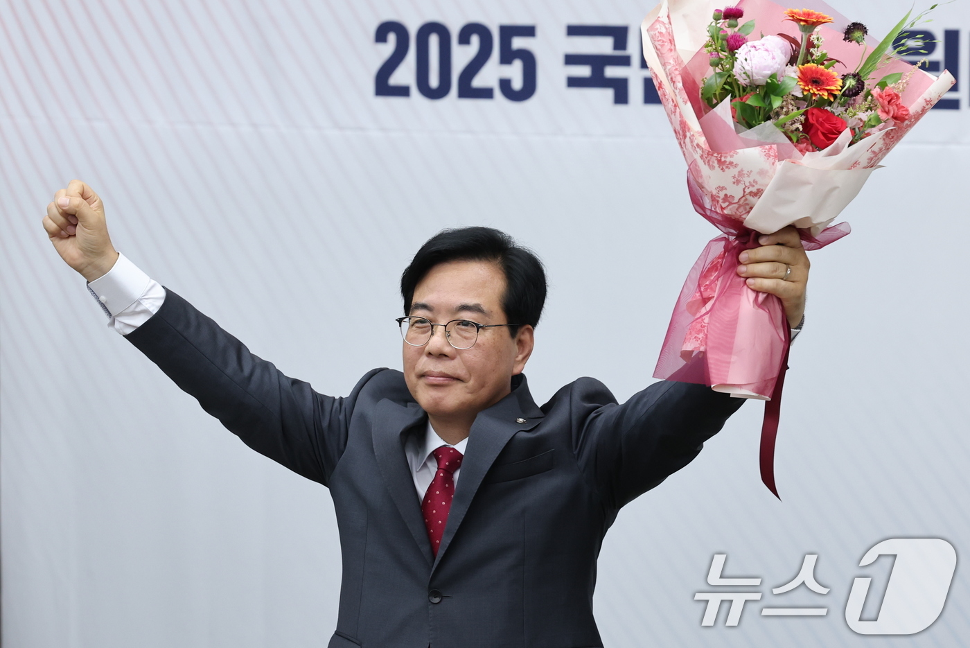 (서울=뉴스1) 안은나 기자 = 국민의힘 신임 원내대표로 선출된 송언석 의원이 16일 오후 서울 여의도 국회에서 열린 의원총회에서 꽃다발을 들어보이고 있다. 2025.6.16/뉴스 …