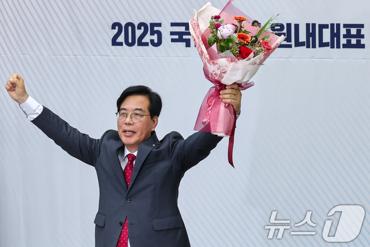 (서울=뉴스1) 안은나 기자 = 국민의힘 신임 원내대표로 선출된 송언석 의원이 16일 오후 서울 여의도 국회에서 열린 의원총회에서 꽃다발을 들어보이고 있다. 2025.6.16/뉴스 …
