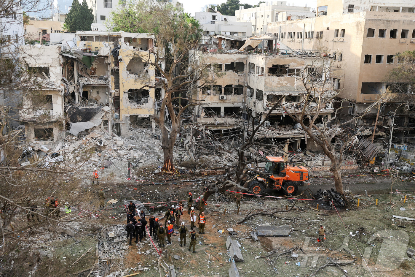 (텔아비브 로이터=뉴스1) 강민경 기자 = 16일 이란이 이스라엘 텔아비브를 향해 미사일이 발사한 후 긴급 구조대가 손상된 건물에 출동해 있다. 2025.6.16ⓒ 로이터=뉴스1