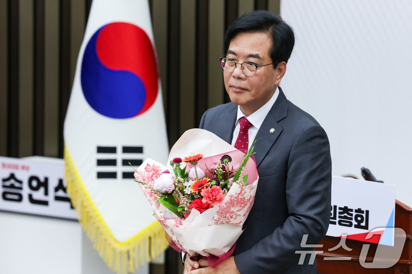 본문 이미지 - 국민의힘 신임 원내대표로 선출된 송언석 의원이 16일 오후 서울 여의도 국회에서 열린 의원총회에서 꽃다발을 들고 있다. 2025.6.16/뉴스1 ⓒ News1 안은나 기자