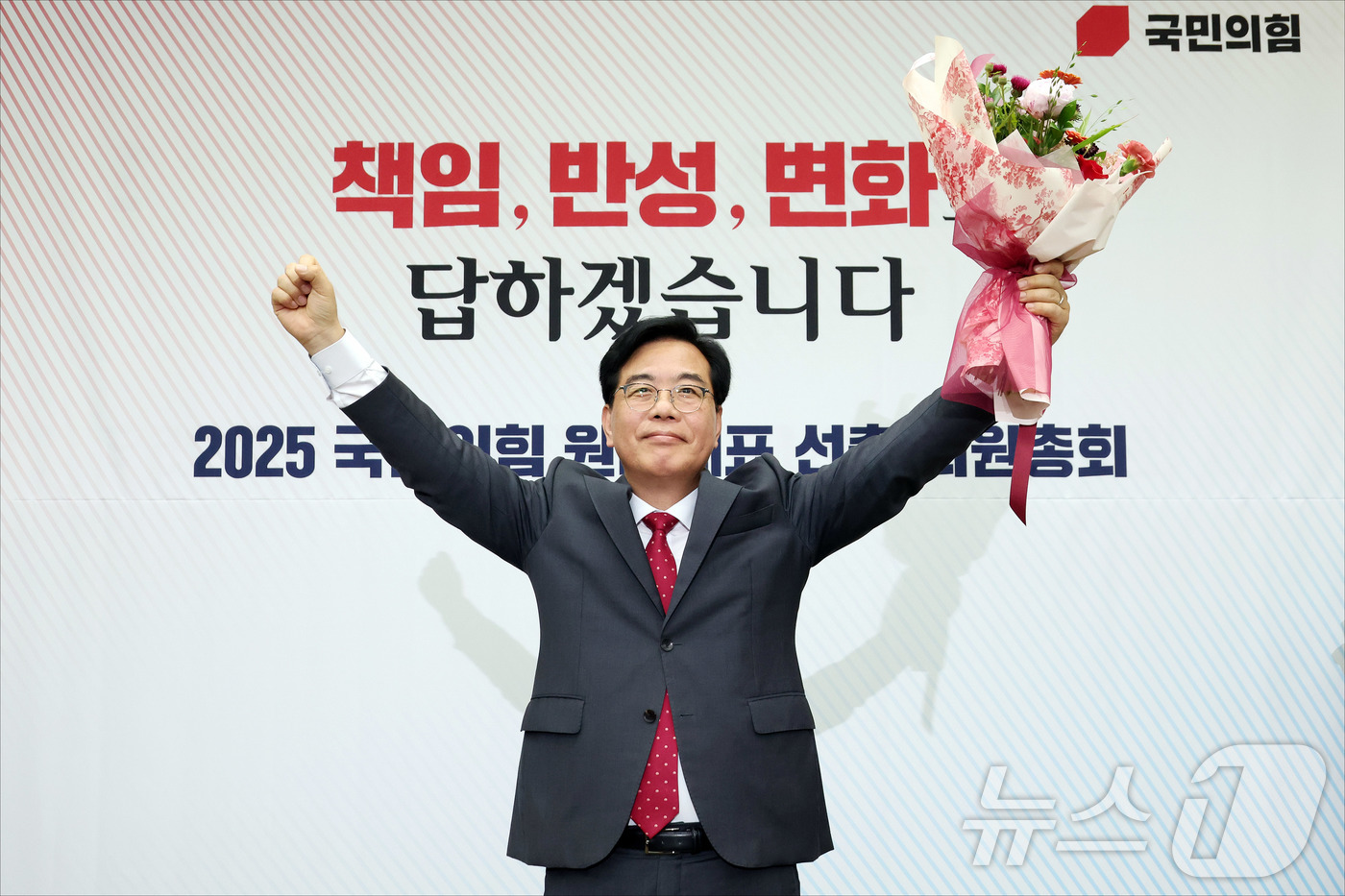 (서울=뉴스1) 이재명 기자 = 송언석 국민의힘 신임 원내대표가 16일 오후 서울 여의도 국회에서 열린 2025 국민의힘 원내대표 선출 의원총회에서 꽃다발을 든 채 손을 들어올리고 …