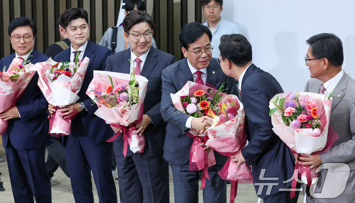 (서울=뉴스1) 안은나 기자 = 국민의힘 신임 원내대표로 선출된 송언석 의원이 16일 오후 서울 여의도 국회에서 열린 의원총회에서 꽃다발을 받은 뒤 김성원 후보와 악수하고 있다. …