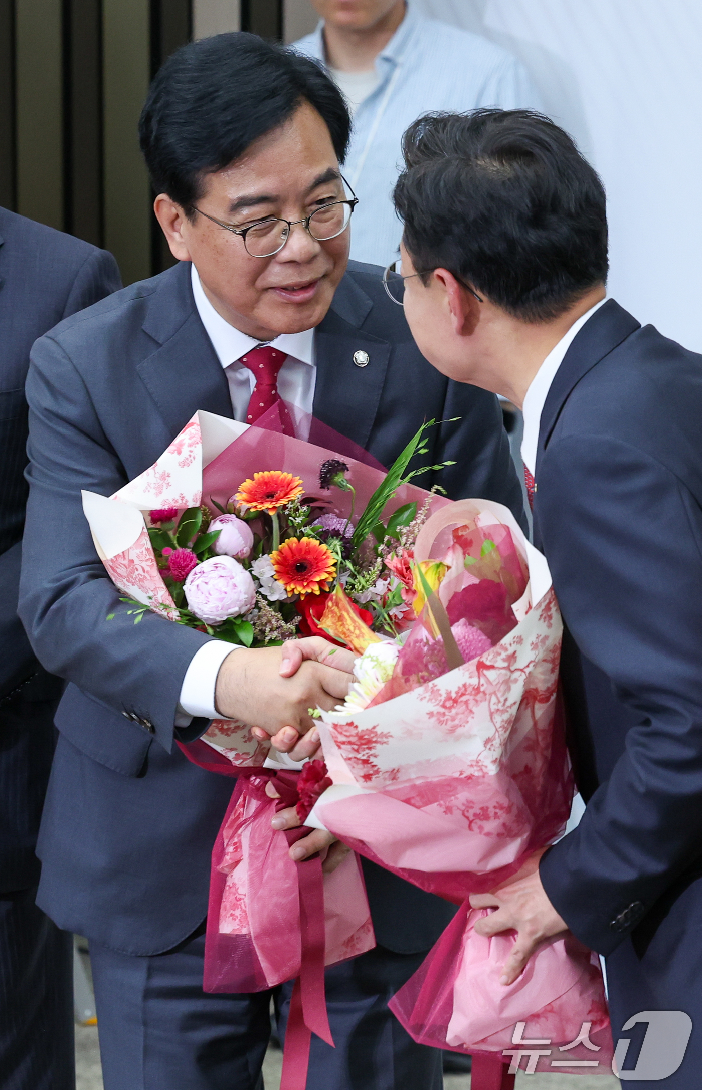 (서울=뉴스1) 안은나 기자 = 국민의힘 신임 원내대표로 선출된 송언석 의원이 16일 오후 서울 여의도 국회에서 열린 의원총회에서 꽃다발을 받은 뒤 김성원 후보와 악수하고 있다. …