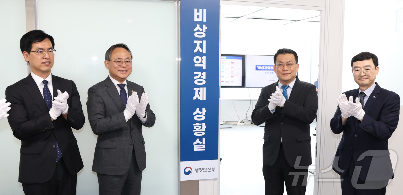 (세종=뉴스1) 김기남 기자 = 고기동 행정안전부 장관 직무대행(왼쪽 두번째)이 17일 세종시 정부세종청사에서 비상지역경제 상황실 개소식에서 참석자들과 현판 제막 후 박수를 치고 …