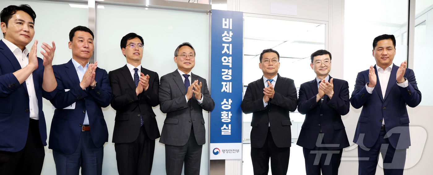 (세종=뉴스1) 김기남 기자 = 고기동 행정안전부 장관 직무대행(왼쪽 네번째)이 17일 세종시 정부세종청사에서 비상지역경제 상황실 개소식에서 참석자들과 현판 제막 후 박수를 치고 …