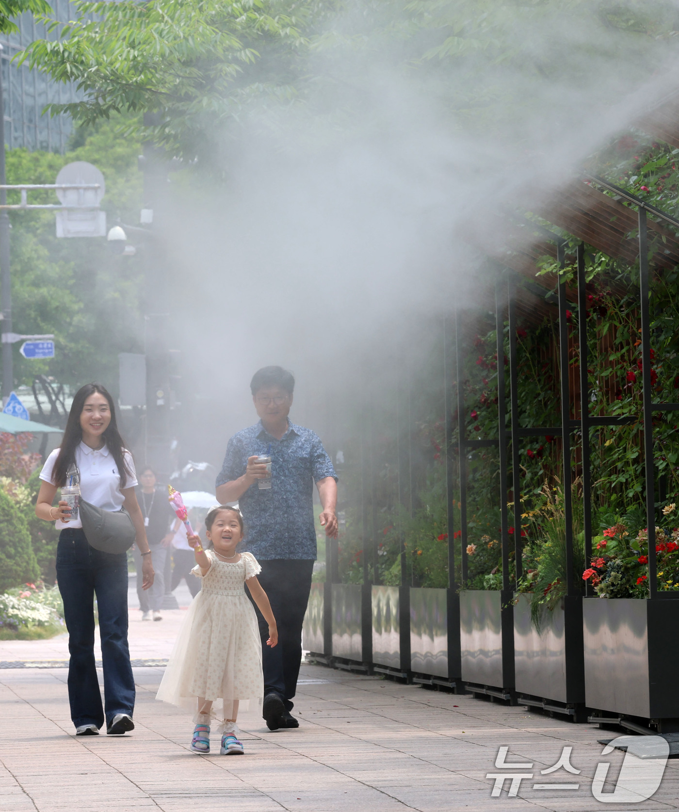 (서울=뉴스1) 박세연 기자 = 서울 최고기온이 29도까지 오르는 등 초여름 날씨를 보인 17일 서울시청 앞 서울광장을 찾은 한 가족이 쿨링포그 앞을 지나며 더위를 식히고 있다.서 …