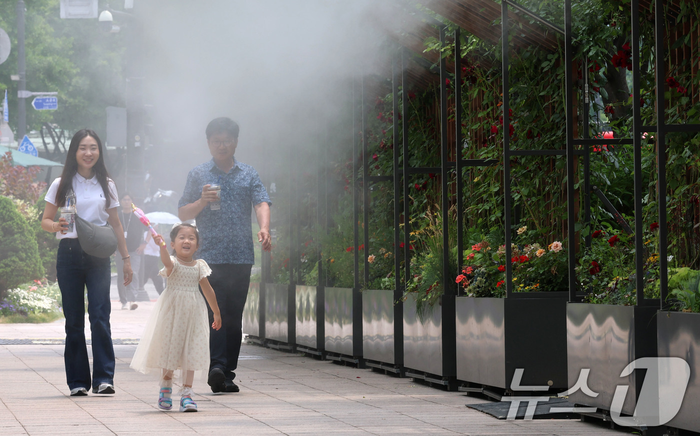 (서울=뉴스1) 박세연 기자 = 서울 최고기온이 29도까지 오르는 등 초여름 날씨를 보인 17일 서울시청 앞 서울광장을 찾은 한 가족이 쿨링포그 앞을 지나며 더위를 식히고 있다.서 …