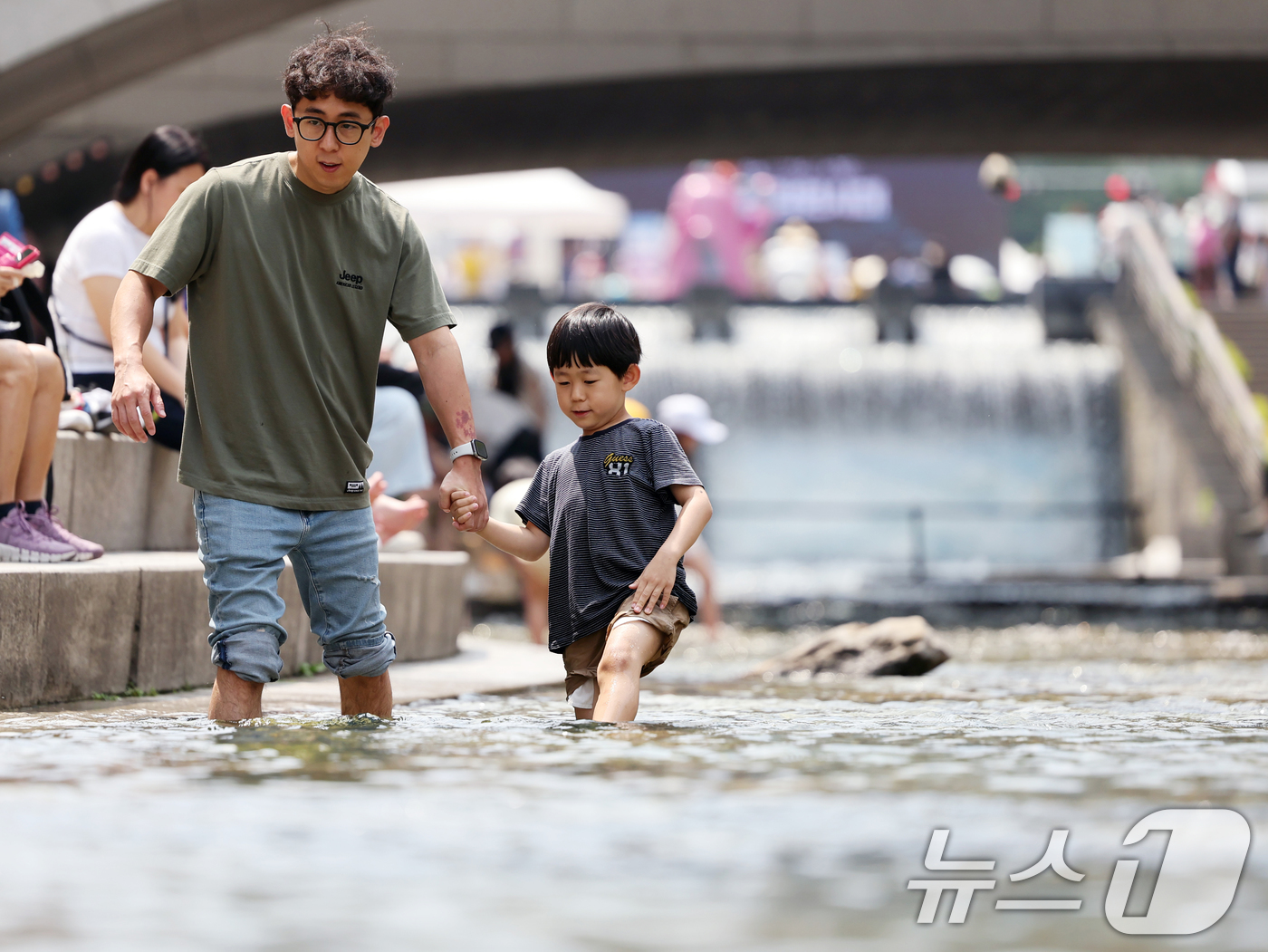 (서울=뉴스1) 황기선 기자 = 서울 최고기온이 29도까지 오르는 등 초여름 날씨를 보인 17일 오후 청계천을 찾은 시민들이 물 속에 발을 담그며 더위를 식히고 있다. 2025.6 …