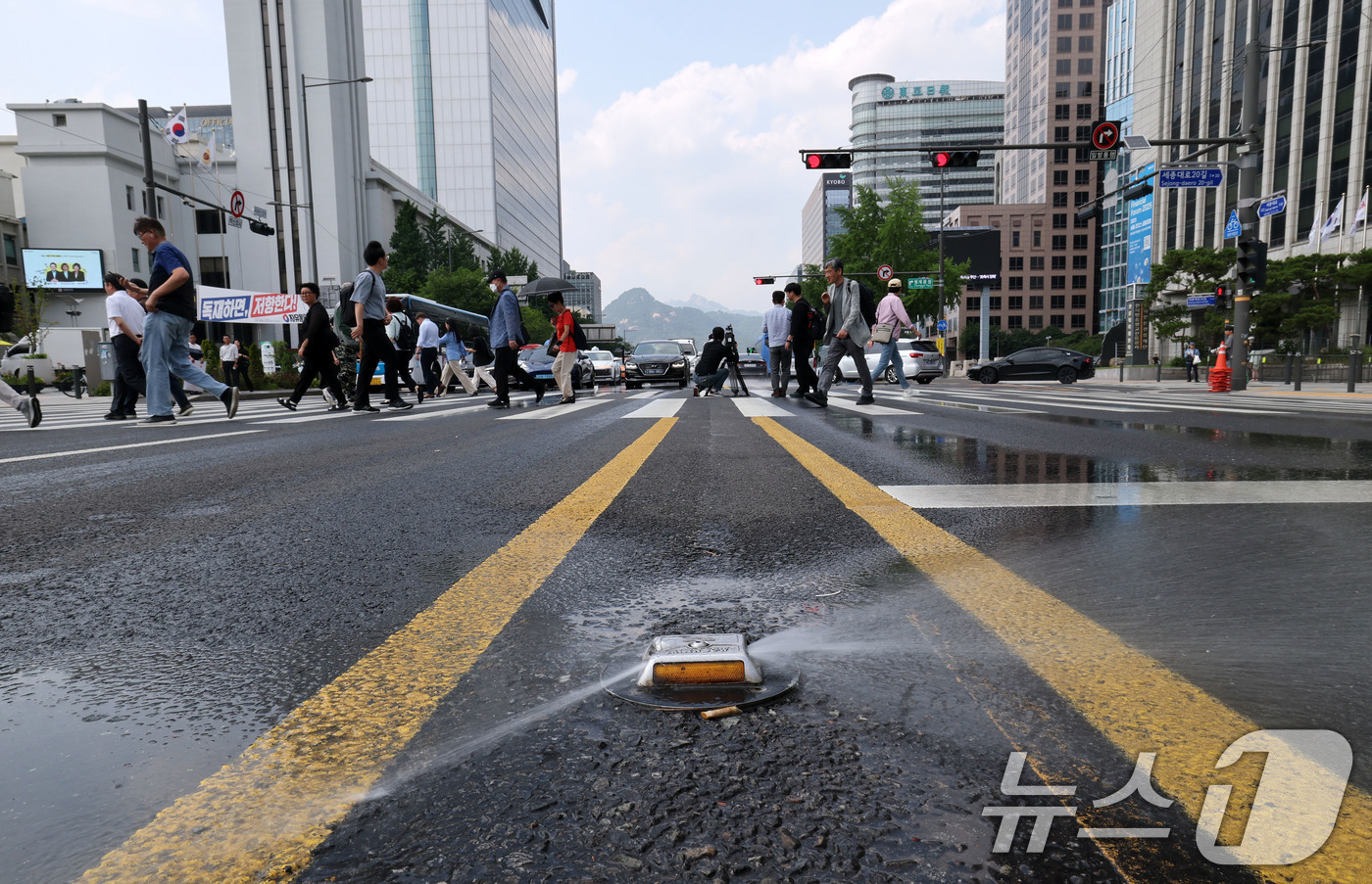 (서울=뉴스1) 박세연 기자 = 서울 최고기온이 29도까지 오르는 등 초여름 날씨를 보인 17일 서울 중구 태평로의 쿨링로드가 물을 뿌리며 도로의 열을 식히고 있다.서울시가 도심 …