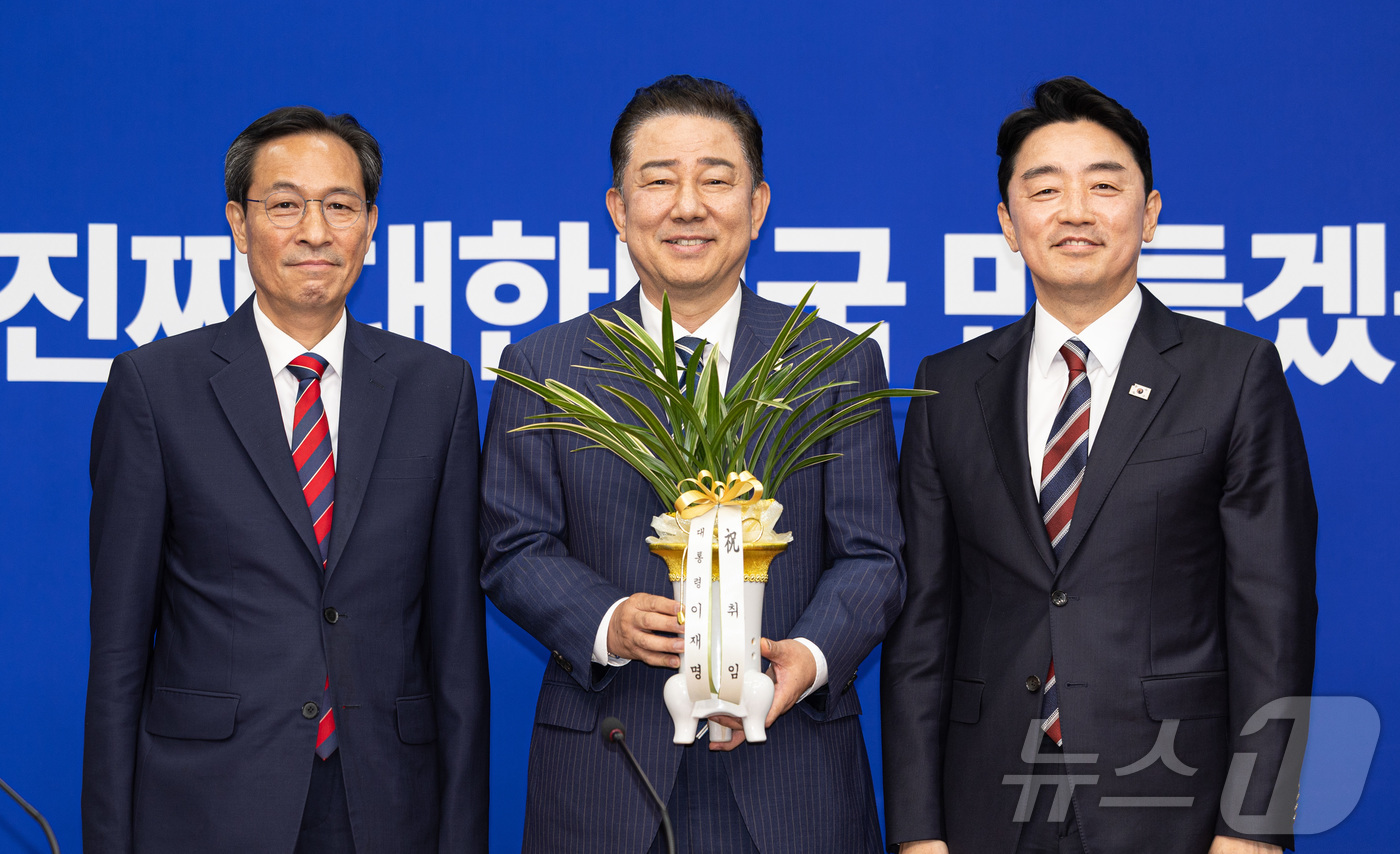 (서울=뉴스1) 이재명 기자 = 김병기 더불어민주당 대표 직무대행 겸 원내대표(가운데)가 17일 오후 서울 여의도 국회에서 강훈식 대통령 비서실장에게 축하난을 전달 받은 후 기념촬 …