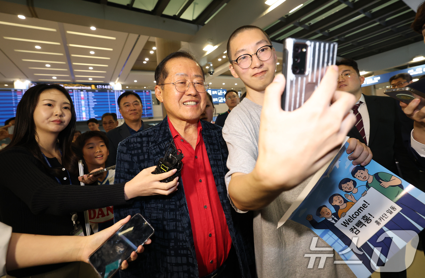 (인천공항=뉴스1) 권현진 기자 = 국민의힘 대선 경선에서 탈락한 뒤 정계 은퇴를 선언하고 하와이로 떠났던 홍준표 전 대구시장이 17일 인천국제공항을 통해 귀국해 지지자와 셀카를 …