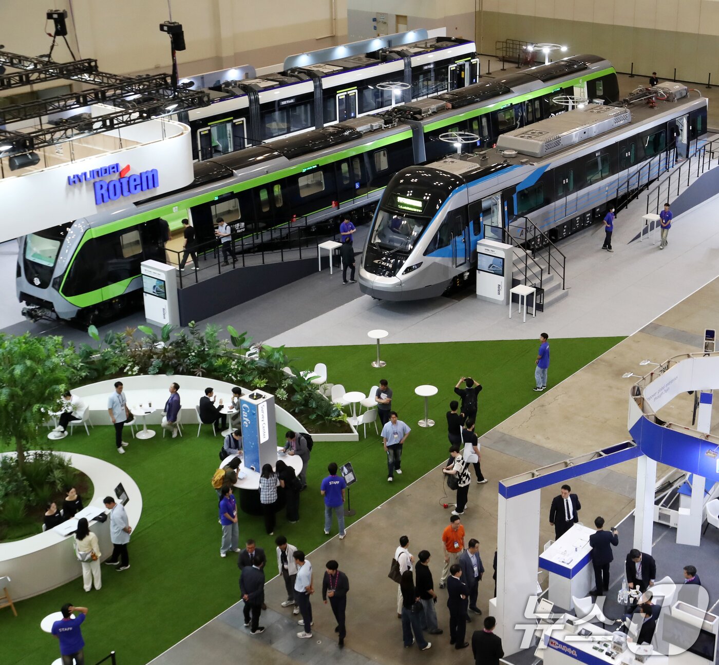 본문 이미지 - 18일 부산 해운대구 벡스코 제1전시장에서 열린 &#39;2025 부산국제철도기술산업전&#39;에서 관람객들이 현대로템의 공항철도 전동차, 대만 그린라인 무인전동차, 캐나다 에드먼턴 밸리라인 웨스트 트램 실물을 둘러보고 있다.  2025.6.18/뉴스1 ⓒ News1 윤일지 기자