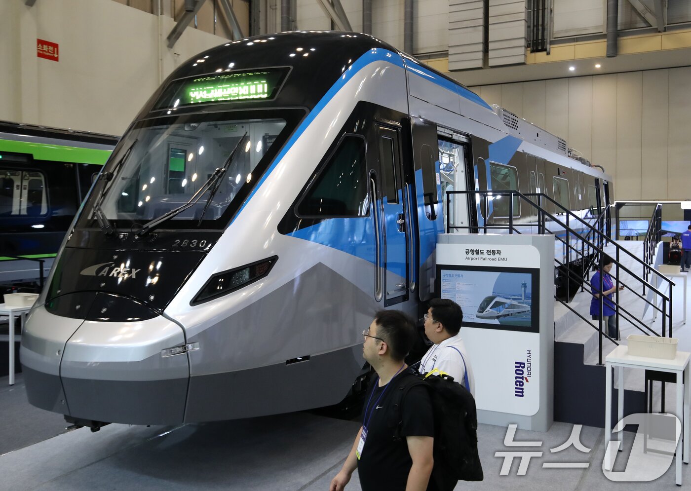 본문 이미지 - 18일 부산 해운대구 벡스코 제1전시장에서 열린 &#39;2025 부산국제철도기술산업전&#39;에서 관람객들이 현대로템의 공항철도 전동차 실물을 둘러보고 있다.  2025.6.18/뉴스1 ⓒ News1 윤일지 기자