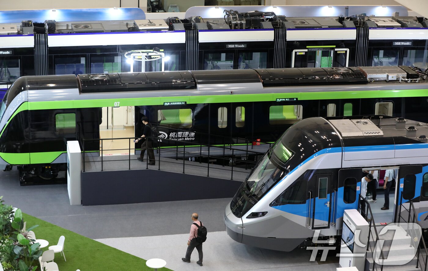 본문 이미지 - 18일 부산 해운대구 벡스코 제1전시장에서 열린 &#39;2025 부산국제철도기술산업전&#39;에서 관람객들이 현대로템의 공항철도 전동차, 대만 그린라인 무인전동차, 캐나다 에드먼턴 밸리라인 웨스트 트램 실물을 둘러보고 있다.  2025.6.18/뉴스1 ⓒ News1 윤일지 기자