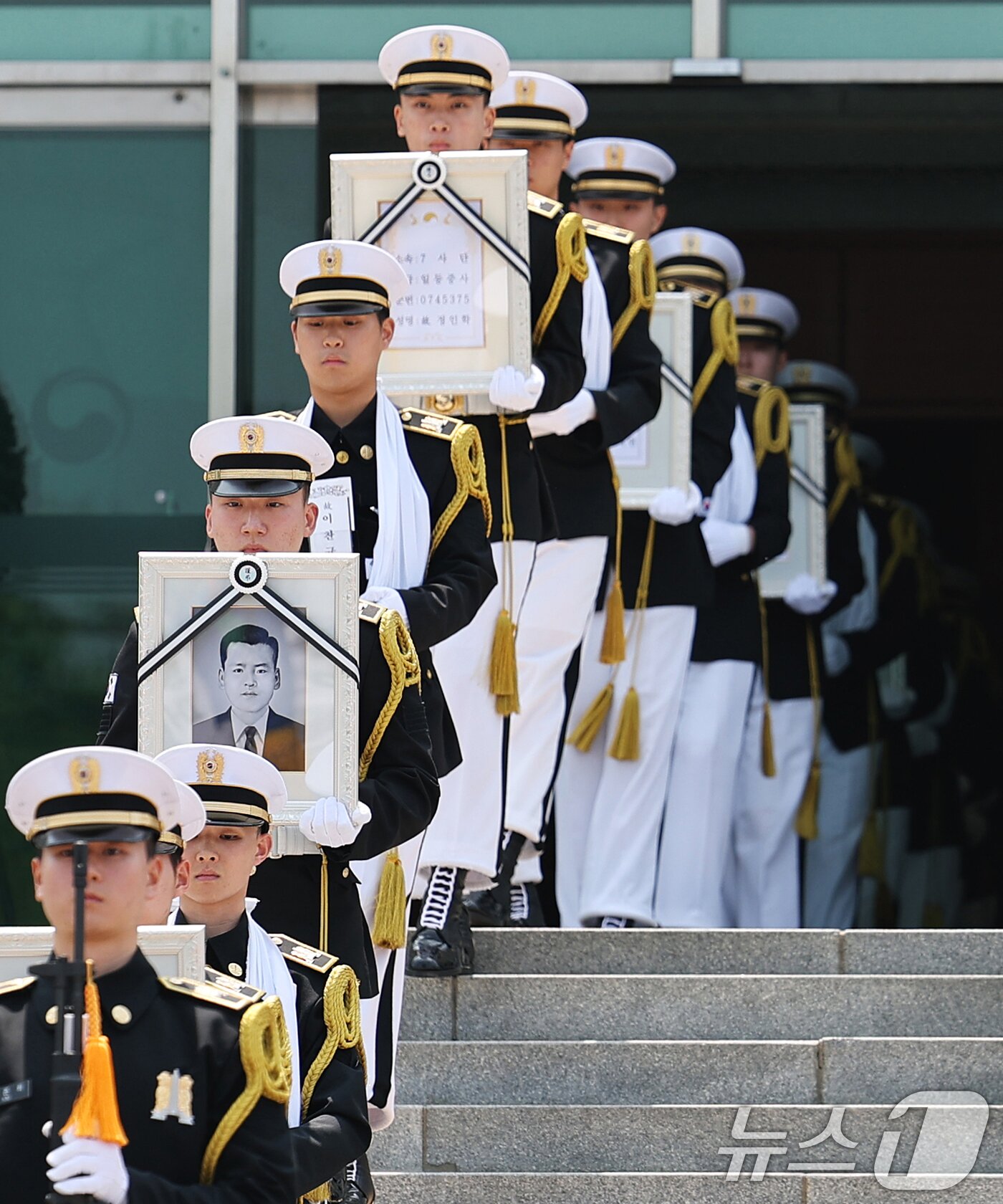 본문 이미지 - 6·25전쟁 75주년을 일주일 앞둔 18일 서울 동작구 국립서울현충원에서 열린 6·25전쟁 전사자 발굴 유해 합동 안장식에서 호국영웅 7위의 영정과 영현이 안장식 장소로 봉송되고 있다. 2025.6.18/뉴스1 ⓒ News1 오대일 기자