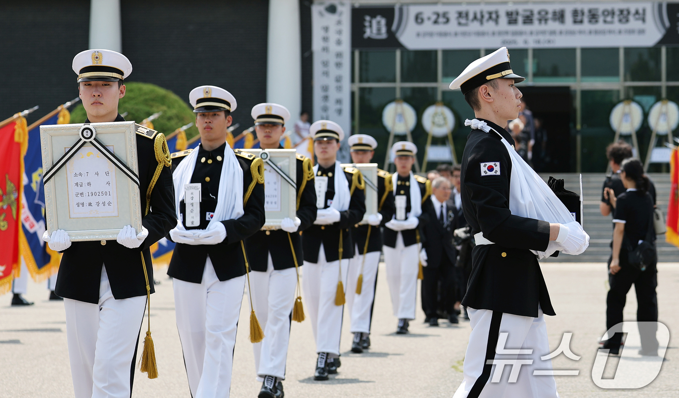 (서울=뉴스1) 오대일 기자 = 6·25전쟁 75주년을 일주일 앞둔 18일 서울 동작구 국립서울현충원에서 열린 6·25전쟁 전사자 발굴 유해 합동 안장식에서 호국영웅 7위의 영정과 …