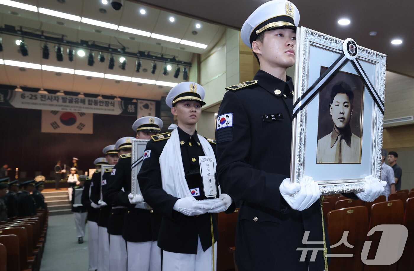 본문 이미지 - 6·25전쟁 75주년을 일주일 앞둔 18일 서울 동작구 국립서울현충원에서 열린 6·25전쟁 전사자 발굴 유해 합동 안장식에서 호국영웅 7위의 영정과 영현이 안장식 장소로 봉송되고 있다. 2025.6.18/뉴스1 ⓒ News1 오대일 기자