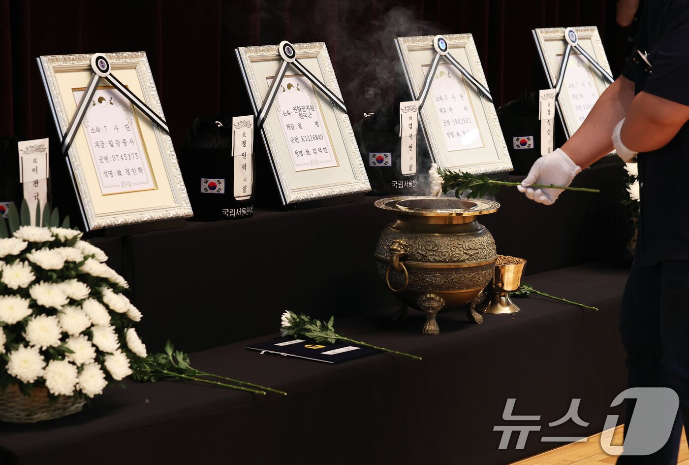 본문 이미지 - 6·25전쟁 75주년을 일주일 앞둔 18일 서울 동작구 국립서울현충원에서 열린 6·25전쟁 전사자 발굴 유해 합동 안장식에서 고 정인학 일등중사 등 호국영웅 7인의 유가족들이 헌화하고 있다. 2025.6.18/뉴스1 ⓒ News1 오대일 기자