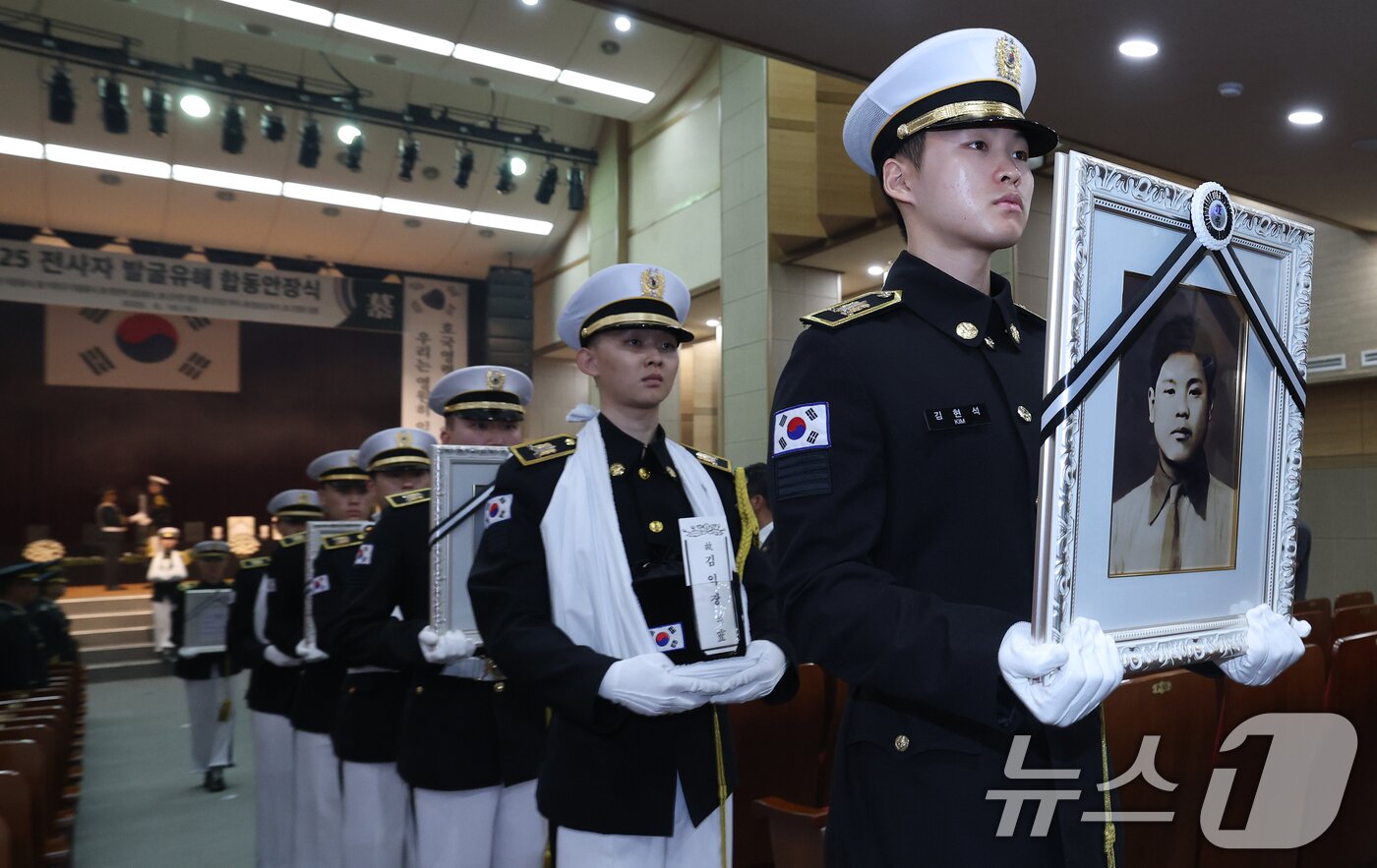 본문 이미지 - 6·25전쟁 75주년을 일주일 앞둔 18일 서울 동작구 국립서울현충원에서 열린 6·25전쟁 전사자 발굴 유해 합동 안장식에서 호국영웅 7위의 영정과 영현이 안장식 장소로 봉송되고 있다. 2025.6.18/뉴스1 ⓒ News1 오대일 기자