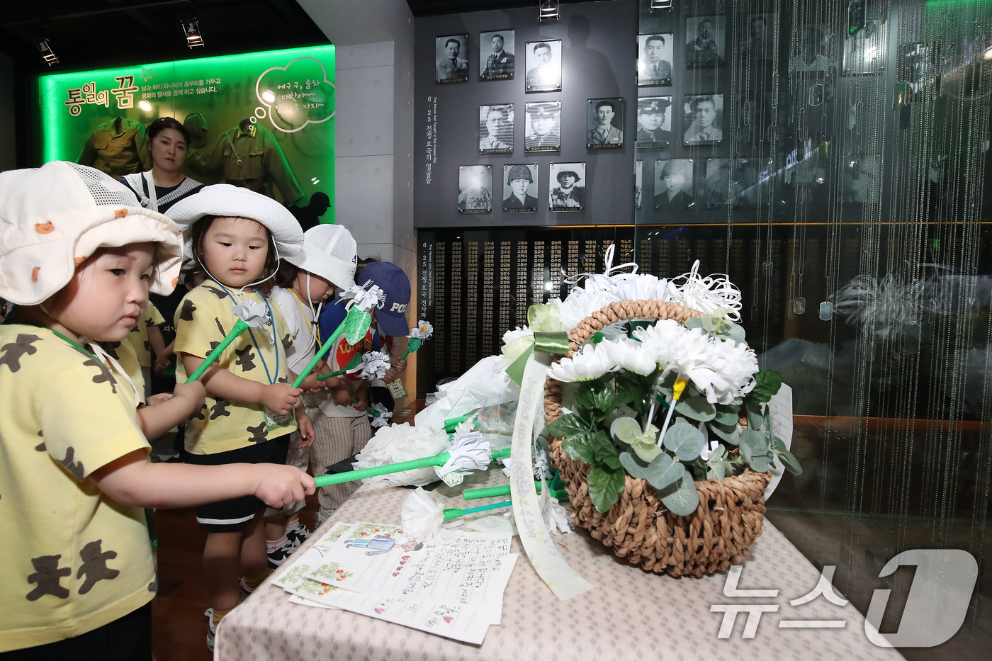 (대구=뉴스1) 공정식 기자 = 6·25전쟁 75주년을 일주일 앞두고 18일 오전 대구 남구 대명동 낙동강승전기념관을 찾은 어린이들이 전몰군경 추모 전시관 앞에서 종이로 만든 국화 …