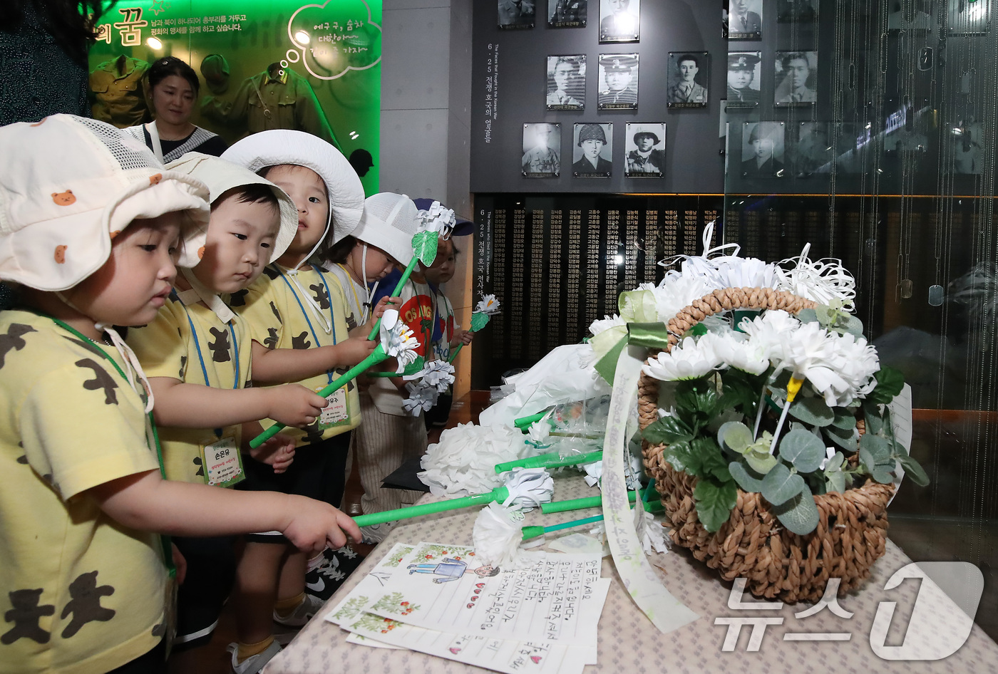 (대구=뉴스1) 공정식 기자 = 6·25전쟁 75주년을 일주일 앞두고 18일 오전 대구 남구 대명동 낙동강승전기념관을 찾은 어린이들이 전몰군경 추모 전시관 앞에서 종이로 만든 국화 …