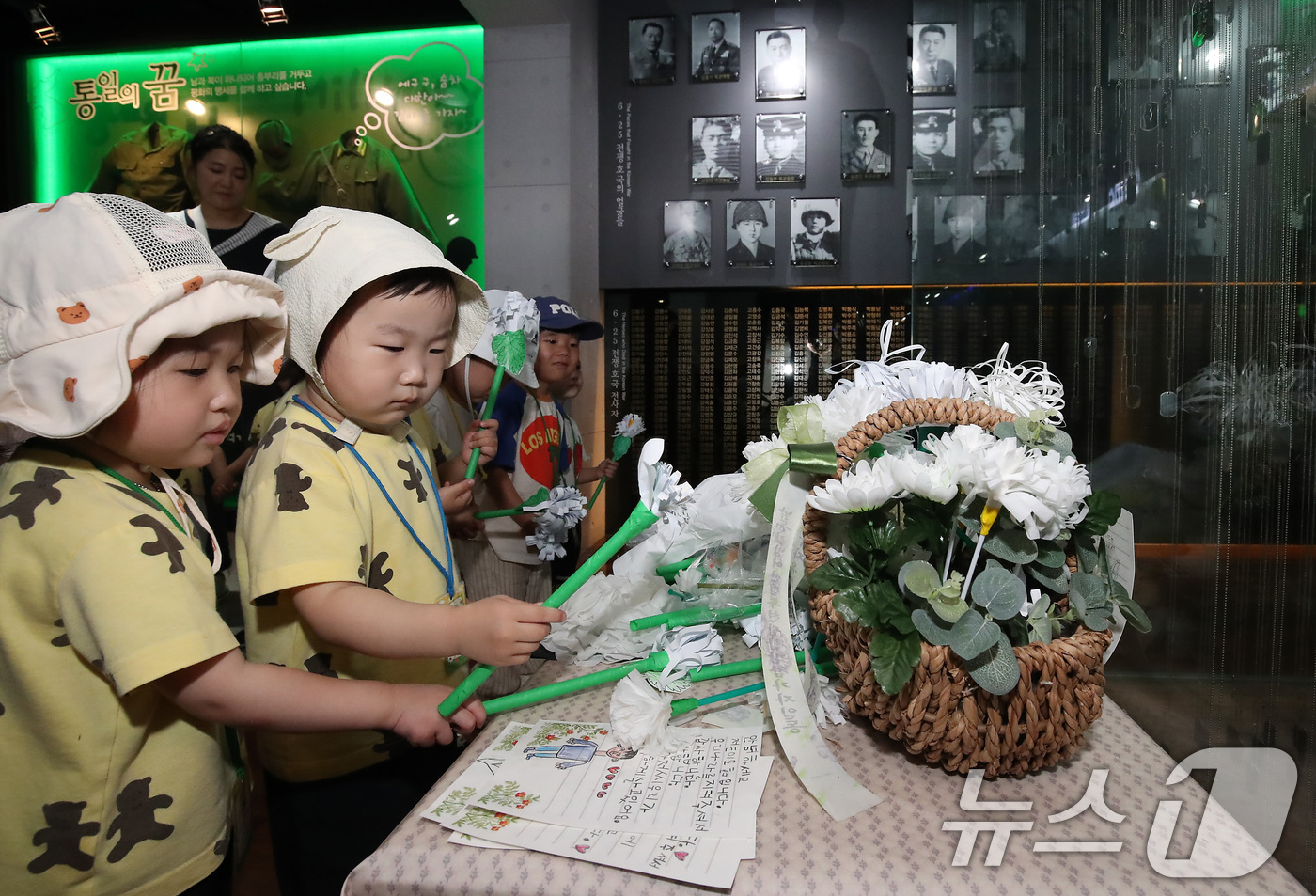 (대구=뉴스1) 공정식 기자 = 6·25전쟁 75주년을 일주일 앞두고 18일 오전 대구 남구 대명동 낙동강승전기념관을 찾은 어린이들이 전몰군경 추모 전시관 앞에서 종이로 만든 국화 …