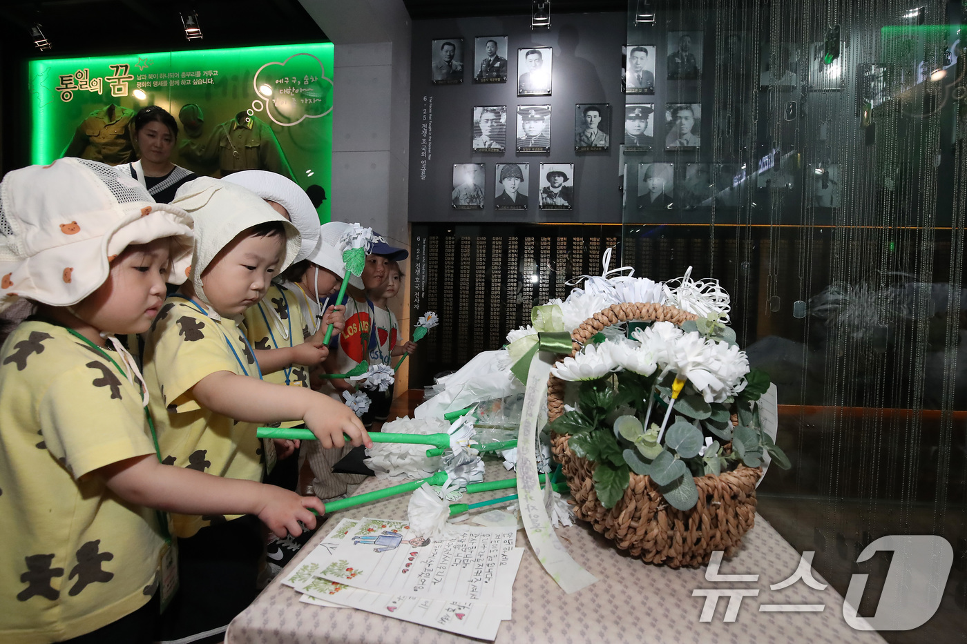 (대구=뉴스1) 공정식 기자 = 6·25전쟁 75주년을 일주일 앞두고 18일 오전 대구 남구 대명동 낙동강승전기념관을 찾은 어린이들이 전몰군경 추모 전시관 앞에서 종이로 만든 국화 …