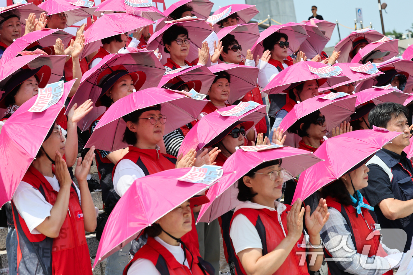 (서울=뉴스1) 안은나 기자 = 서울 낮 최고기온이 31도까지 오른 18일 서울 여의도 국회 본청 계단에서 돌봄노동자 하루멈춤 투쟁 기자회견에 참석한 민주노총 서비스연맹 전국돌봄서 …