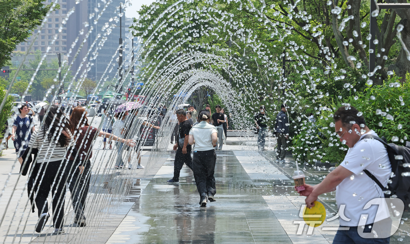 (서울=뉴스1) 장수영 기자 = 최고기온이 30도를 넘으며 무더위가 이어진 18일 서울 종로구 광화문광장 바닥분수로 시민들이 지나가고 있다. 2025.6.18/뉴스1