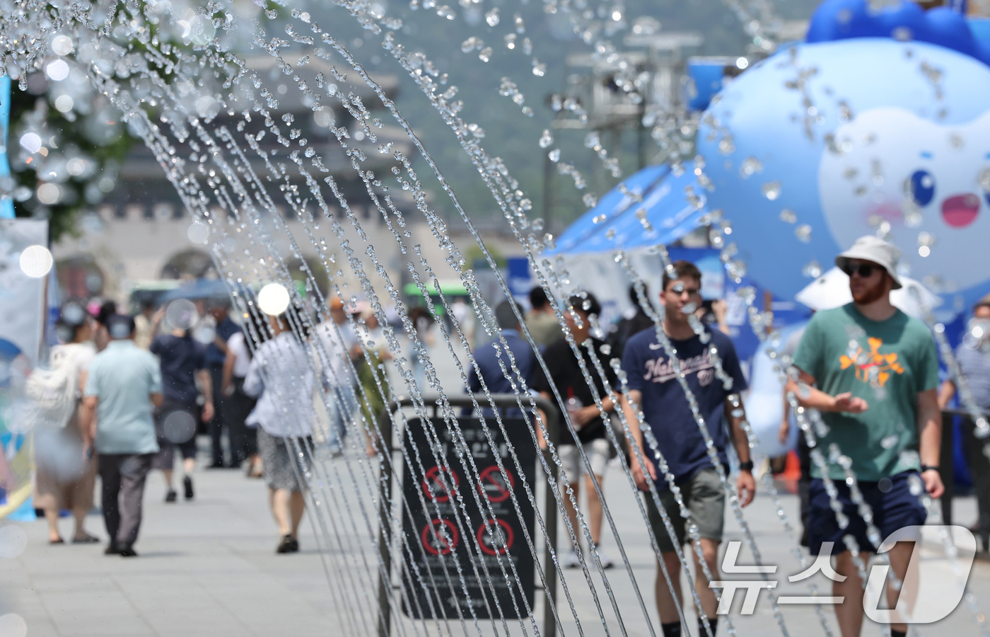 (서울=뉴스1) 장수영 기자 = 최고기온이 30도를 넘으며 무더위가 이어진 18일 서울 종로구 광화문광장 바닥분수 앞으로 관광객들이 지나가고 있다. 2025.6.18/뉴스1