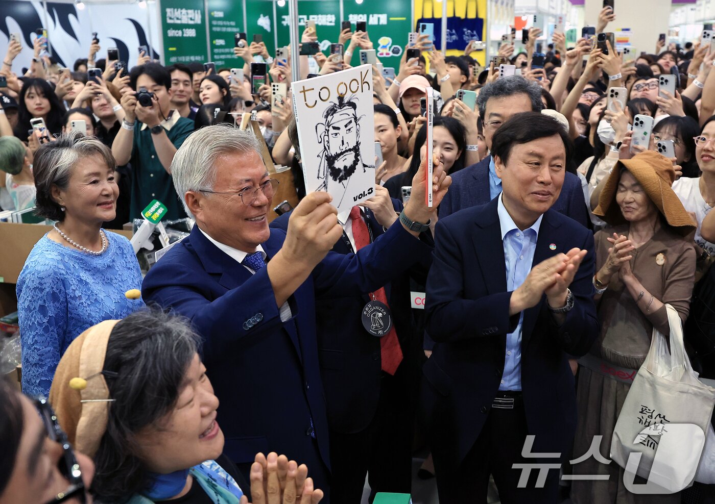 본문 이미지 - 문재인 전 대통령과 김정숙 여사가 18일 오후 서울 강남구 삼성동 코엑스에서 열린 2025 서울국제도서전 평산책방 부스를 찾아 괴산로컬잡지 툭의 임꺽정 특집호를 들어 보이고 있다. 2025.6.18/뉴스1 ⓒ News1 박정호 기자