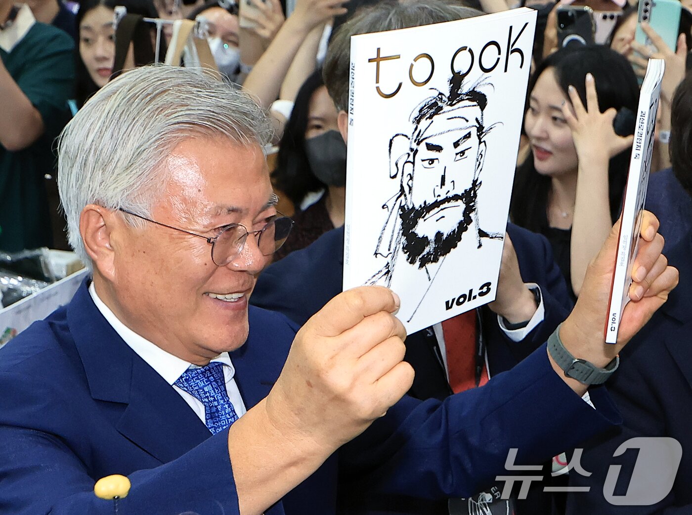 본문 이미지 - 문재인 전 대통령과 김정숙 여사가 18일 오후 서울 강남구 삼성동 코엑스에서 열린 2025 서울국제도서전 평산책방 부스를 찾아 괴산로컬잡지 툭의 임꺽정 특집호를 들어 보이고 있다. 2025.6.18/뉴스1 ⓒ News1 박정호 기자