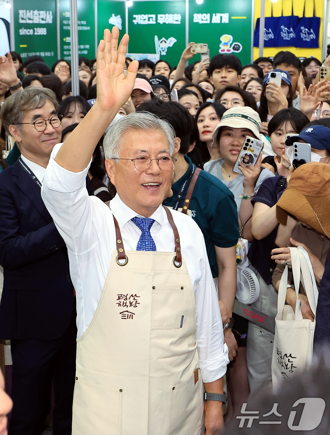(서울=뉴스1) 박정호 기자 = 문재인 전 대통령이 18일 오후 서울 강남구 삼성동 코엑스에서 열린 2025 서울국제도서전 평산책방 부스에서 앞치마를 두르고 나와 방문객들에게 인사 …