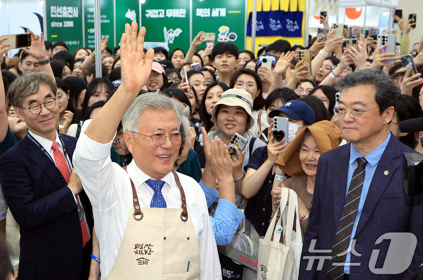(서울=뉴스1) 박정호 기자 = 문재인 전 대통령이 18일 오후 서울 강남구 삼성동 코엑스에서 열린 2025 서울국제도서전 평산책방 부스에서 앞치마를 두르고 나와 방문객들에게 인사 …